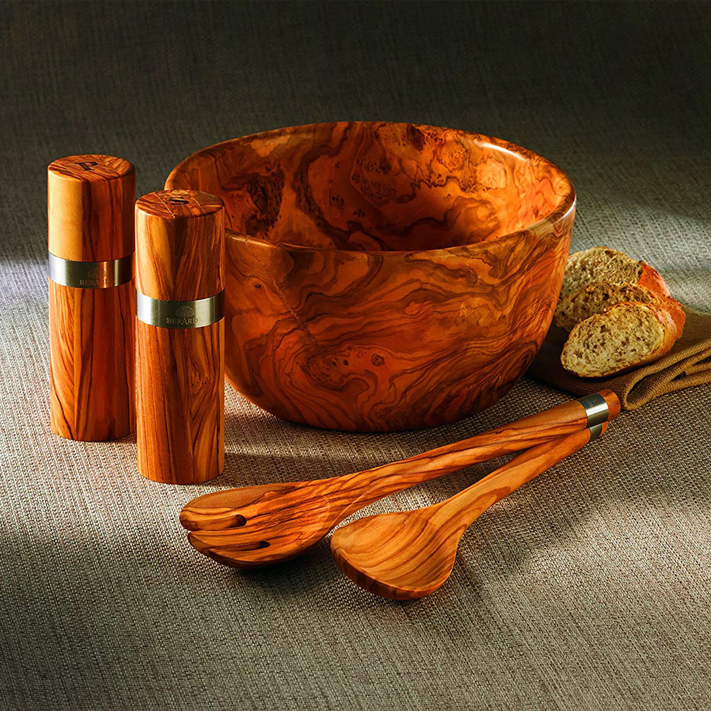 Berard France olive wood salad server set, salt and pepper shakers and bowl neatly arranged on a table.