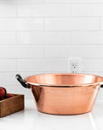 de Buyer Copper Jam Pan sitting on a white counter with white tile backsplash behind it.