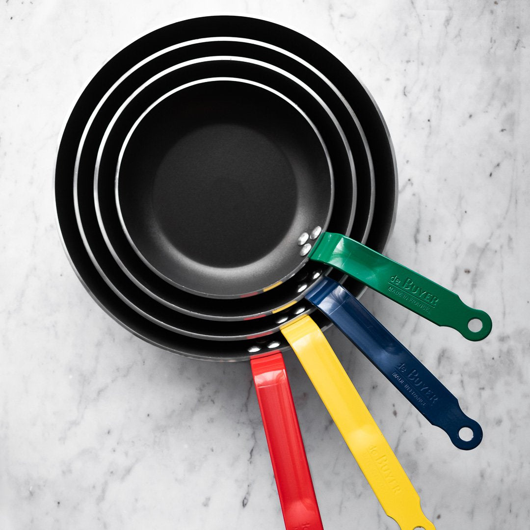 de Buyer CHOC Nonstick Frying Pans nested together on a granite counter.